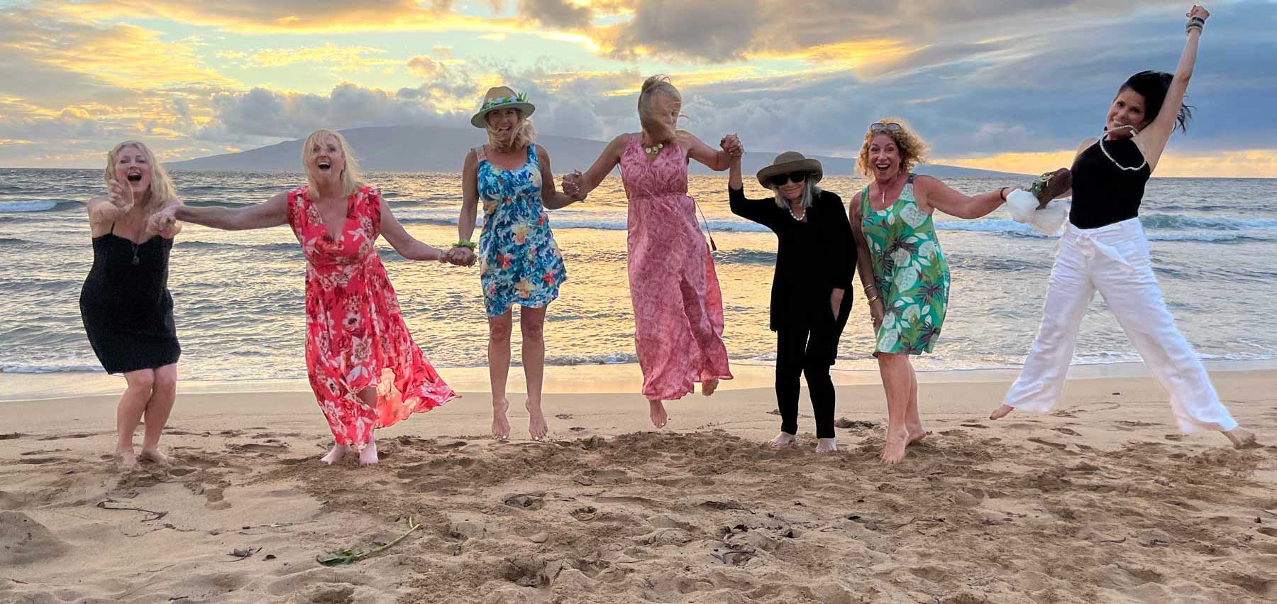 Author celebrating with arms raised on the beach